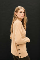 Female model wearing Jumper 1234 Oversize camel roll neck in our cashmere and wool blend, heavier weight with a great button detail on one side.