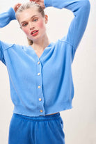 Blonde female model wearing Jumper 1234 Blue cashmere vee neck cardigan with 'distressed' ribs