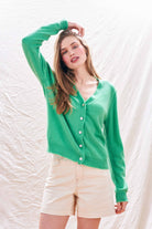Blonde female model wearing Jumper 1234 Green cashmere vee neck cardigan with 'distressed' ribs.