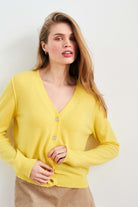 Blonde female model wearing Jumper 1234 Yellow cashmere vee neck cardigan with 'distressed' ribs