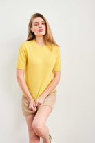 Female model wearing Jumper 1234 Yellow short sleeve cashmere jumper with 'distressed' ribs.