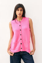 Brown haired female model wearing Jumper1234 neon pink cashmere sleeveless guernsey cardigan
