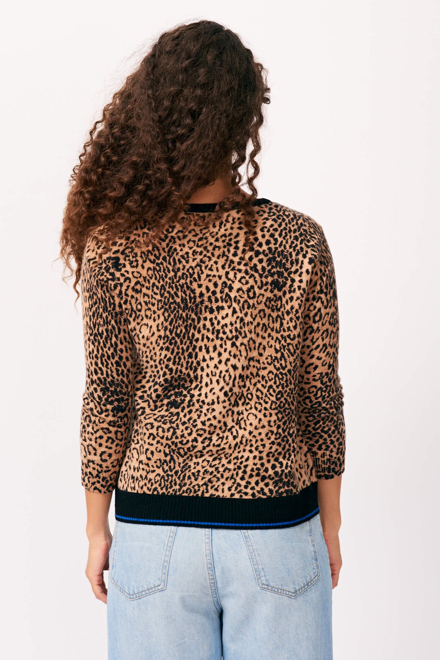 Brown haired female model wearing Jumper 1234 cashmere wool blend leopard print cashmere cardigan facing away from the camera